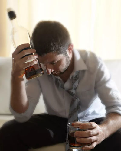 мужчина со стаканом и бутылкой алкоголя