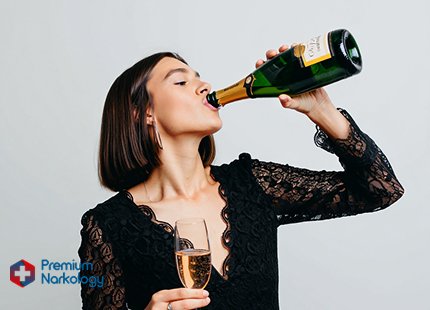 Девушка в праздничном платье пьет шампанское